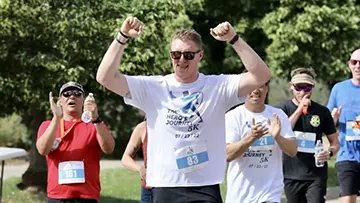 Zack Golditch celebrates during the Hero's Journey 5K